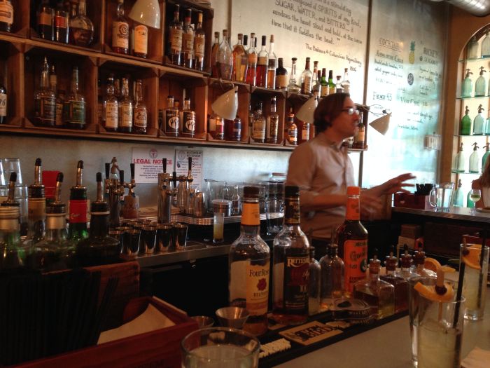 Derek Brown behind the bar, well stocked with Southern bourbons and whiskeys.